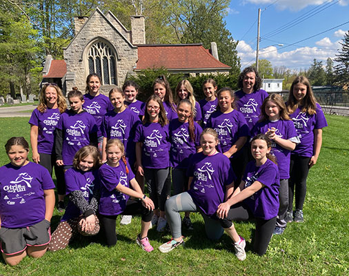 Girls on the Run team and coaches posing in a group outside 