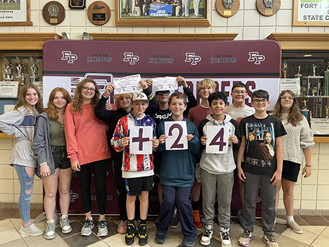 group of students holding cards saying + 24