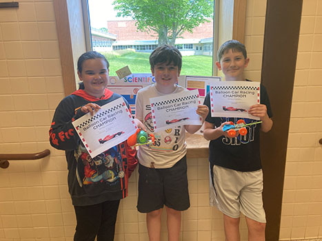 3 students holding certificates that say Balloon Car Racing Champion