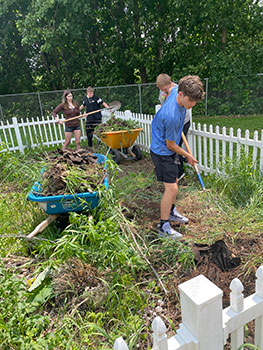 students working hard to clean up the community garden