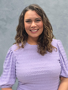 Fort Plain Jr/Sr High School Principal, Katrina Canallatos, who has long light brown hair and is wearing a purple top, looks at and smiles for the camera.